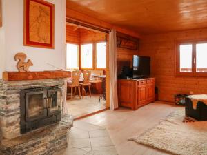 een woonkamer met een open haard en een televisie bij Chalet L'aïeul by Interhome in Nendaz +30 foto's