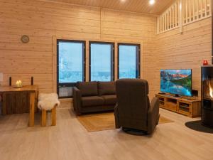 a living room with a couch and a tv at Holiday Home Villa viima by Interhome in Saariselka