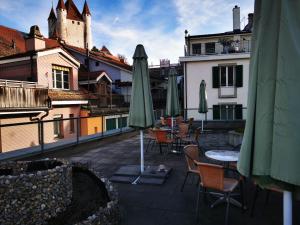 un patio con tavoli, sedie e ombrelloni in un edificio di Apartment B&B am Berntor by Interhome a Thun