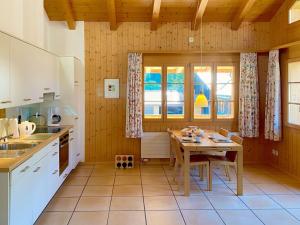 a kitchen with a table and a dining room at Apartment Haus Lohnerblick by Interhome in Kandersteg