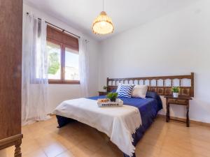 una camera con un letto blu e una finestra di Holiday Home Urb Riumar by Interhome a Deltebre