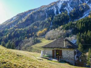 Holiday Home Rustico Stübii by Interhome في Campo Blenio: منزل صغير على تل مع جبل