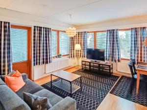 ein Wohnzimmer mit einem Sofa und einem TV in der Unterkunft Holiday Home Karhunvartijan pirtti c 2 by Interhome in Ruka