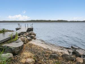 a dock with two benches on a body of water at Holiday Home Tyssinniemi by Interhome in Hiukkajoki