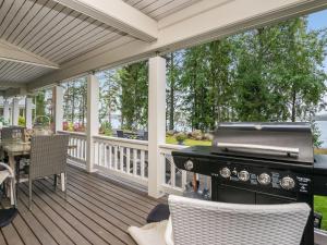 eine abgeschirmte Veranda mit einem Grill und einem Tisch in der Unterkunft Holiday Home Tyssinniemi by Interhome in Hiukkajoki