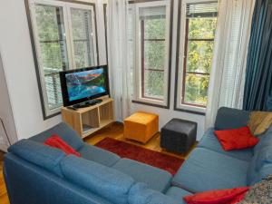 un salon avec un canapé bleu et une télévision dans l'établissement Holiday Home Pulkka 3 by Interhome, à Tikkala