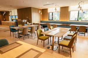 a dining room with wooden tables and chairs at Holiday Inn Express Yingkou Onelong Plaza by IHG in Gaizhou