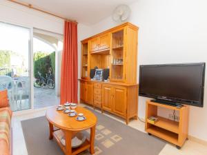 a living room with a flat screen tv and a table at Apartment Residencial Eurosol de los Monteros by Interhome in Miami Platja +14 photos