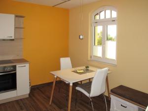 una cucina con tavolo, sedie e finestra di Apartment Nelke by Interhome a Zarrentin