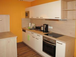 una cucina con mobili bianchi e un forno a piano cottura di Apartment Nelke by Interhome a Zarrentin