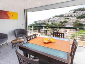 a dining room with a table and chairs and a large window at Apartment Naranja by Interhome in Tossa de Mar