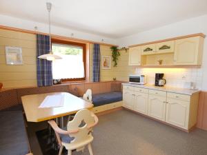 a kitchen with a desk and a table and chairs at Holiday Home Zeller by Interhome in Stummerberg