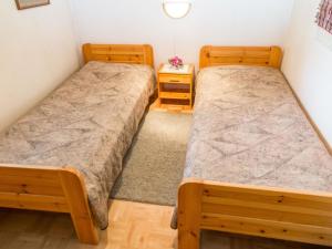 two twin beds in a room with two night stands at Holiday Home Tintintaival 2 a 8 by Interhome in Tahkovuori