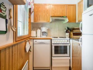 a kitchen with a stove and a refrigerator at Holiday Home Tintintaival 2 a 8 by Interhome in Tahkovuori