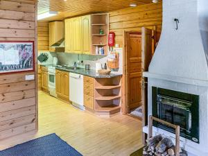 eine Küche mit Kamin in einer Blockhütte in der Unterkunft Holiday Home Lehtotuvat e by Interhome in Kotila