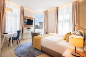 Postel nebo postele na pokoji v ubytování SEETELHOTEL Ostseehotel das Entdeckerhotel an der Ostsee und der perfekte Startpunkt für Ihre Inselabenteuer