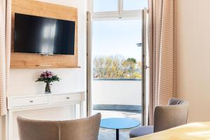 TV a/nebo společenská místnost v ubytování SEETELHOTEL Ostseehotel das Entdeckerhotel an der Ostsee und der perfekte Startpunkt für Ihre Inselabenteuer