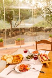 una mesa con platos de comida y copas de vino en Agriturismo Canales, en Dorgali