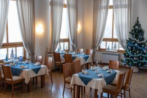 un comedor con mesas azules y un árbol de Navidad en 40th Meridian Yacht Club, en Kolomna