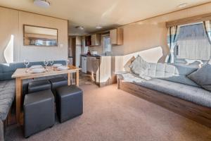 ein Wohnzimmer mit einem Sofa und einem Tisch in der Unterkunft Lakeside, Thorpe Park Cleethorpes Static Caravan in Cleethorpes