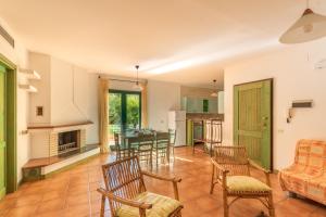 sala de estar con chimenea, mesa y sillas en Residence I Mirti Bianchi, en Santa Teresa Gallura