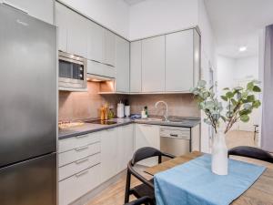 a kitchen with white cabinets and a table with a vase at Limehome Madrid Calle de Don Ramón de la Cruz in Madrid