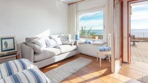 sala de estar con sofá y vistas al océano en ELS CANYERS en Calella de Palafrugell