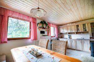 eine Küche mit einem Tisch und Stühlen sowie einem Fenster in der Unterkunft Alpine house Antonia in Trenta