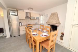 a kitchen with a wooden table with chairs and a fireplace at Villa Ivana in Korčula