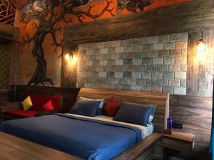 ein Schlafzimmer mit einem Bett mit einem Wandbaum in der Unterkunft Shivaaz Holiday Farms - Near Mopa Airport Goa in Dodamarg
