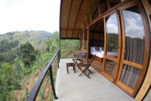 a balcony of a house with a bed and a bedroom at Riverbank Resort Gampola in Gampola