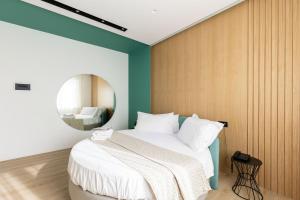 una camera da letto con un grande letto e uno specchio rotondo di Plana Hotel a Caserta