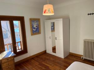 a bedroom with white walls and a window and a mirror at Plein soleil in Briançon