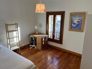 Schlafzimmer mit einem Bett, einem Schreibtisch und einem Fenster in der Unterkunft Plein soleil in Briançon