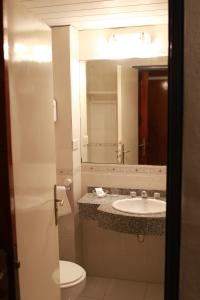 a bathroom with a sink and a toilet and a mirror at Hotel Posta del Sol Paraná in Paraná