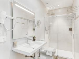 uma casa de banho branca com um lavatório e um chuveiro em limehome Málaga Calle Ancha del Carmen - Digital Access em Málaga
