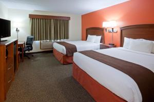 a hotel room with two beds and a desk and a television at AmericInn by Wyndham Virginia in Virginia