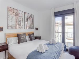 1 dormitorio con cama blanca y ventana en limehome Málaga Calle Ancha del Carmen - Digital Access, en Málaga