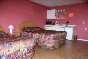 a hotel room with two beds and a kitchen at Elks Motel in Keremeos