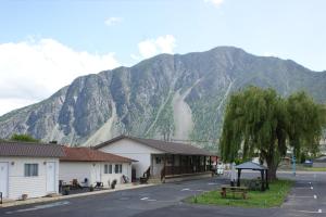 a mountain in the background of a town with a building at Elks Motel in Keremeos