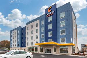 a building with a car parked in front of it at Comfort Suites Cottage Grove-Madison in Cottage Grove