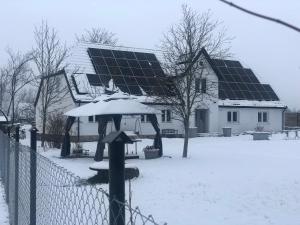 una casa con muchos paneles solares en la nieve en Dom nad morzem Ludwikowo, en Skrzeszewo
