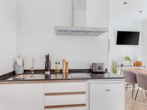 a white kitchen with a sink and a counter top at limehome Málaga Calle Ancha del Carmen - Digital Access in Málaga