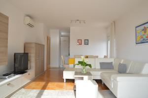 a living room with a white couch and a tv at Apartment Silvija sea view in Umag