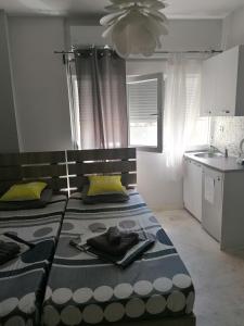 a bedroom with two beds and a kitchen with a ceiling at Aristotelous 1 min supercentral Mini studio- renewed with brand new professional orthopedic mattresses in Thessaloniki