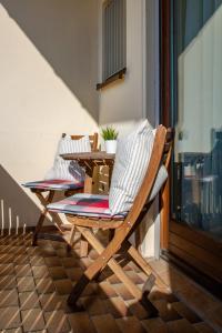 a wooden chair on a balcony with a table at Hotel Bastei in Altmühldorf