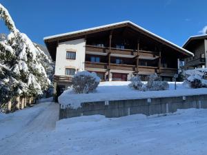 un edificio con nieve en el suelo delante de él en Haus Alpenruhe, en Bad Kleinkirchheim