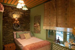 a bedroom with a bed and a stone wall at Dandy Villas Metsovo-Metska-Down Town-Up to 7 in Metsovo