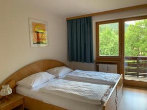 1 dormitorio con cama y ventana grande en Haus Alpenruhe, en Bad Kleinkirchheim