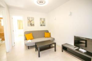 a living room with a couch and a table at New Miami Playa Apartamentos in San Agustin